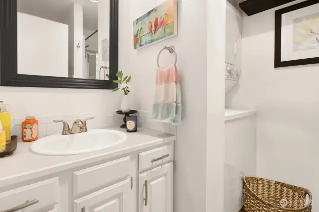 Located in the foyer, this 3/4 bath hosts the laundry.  Cabinets are freshly painted!