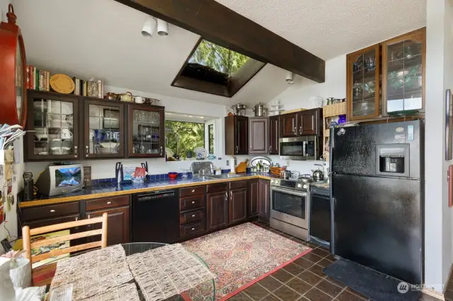 Alternate view of kitchen with Bosch appliances, solid wood cabinetry, tile countertops and flooring