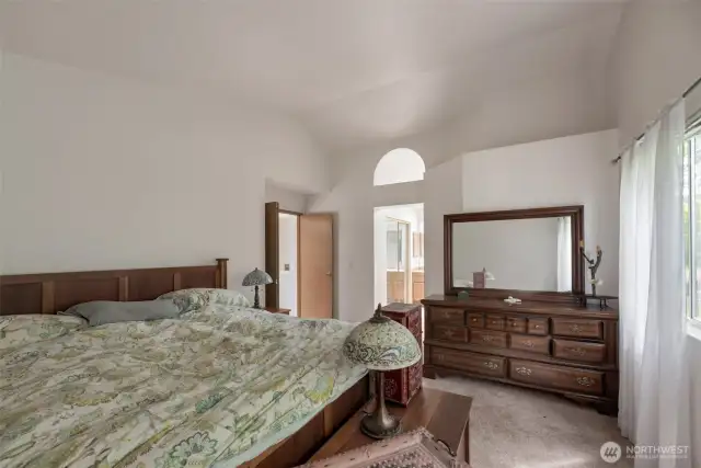 Primary bedroom with vaulted ceiling, walk in closet, and 5 piece bath