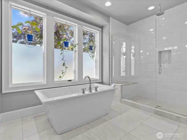Enjoy a superb soaking tub alongside a generously sized shower featuring two shower heads—one of which is a rain shower—offering versatile and luxurious bathing experiences.