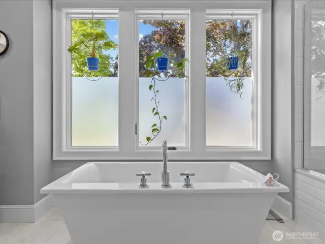 Unwind in the deep-soaking tub, surrounded by privacy film that ensures seclusion while still allowing an abundance of natural light to fill the space.