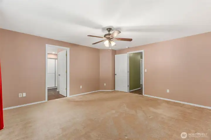 Thisis the primary bedroom. The primary bathroom is through the door on the left. The door on the right leads to the hallway and additional bedrooms.