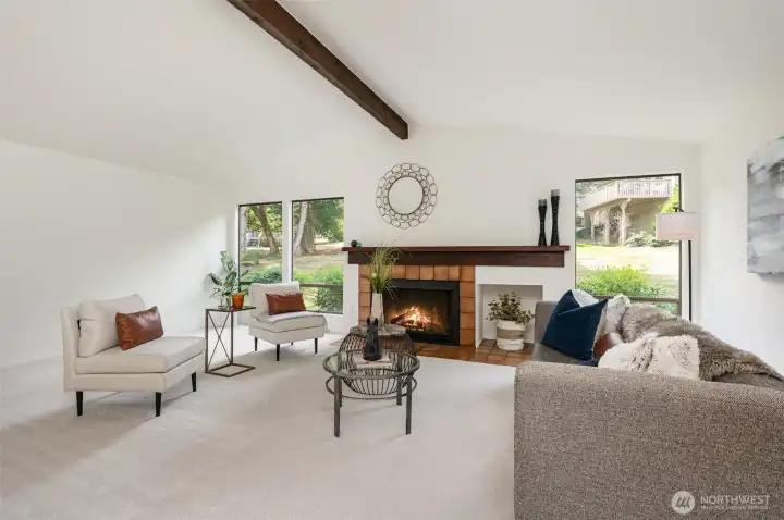 Spacious  great room with vaulted ceilings, large windows and cozy fireplace.