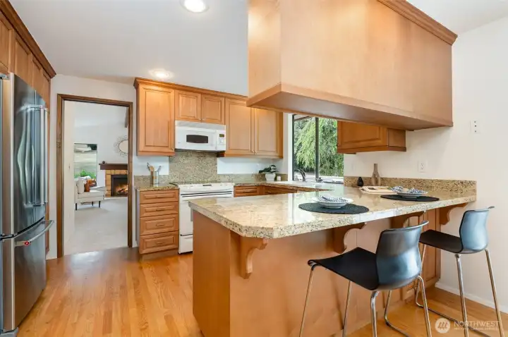 Plenty of counterspace and cabinets in your kitchen with granite tile counters and newer stainless refrigerator.