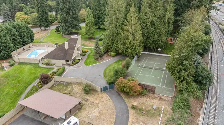 Arial view of clubhouse, pool, tennis courts and RV/boat parking area. Note the light rail line on right hand side of photo!