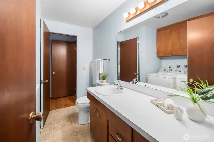 The newer water heater will keep the shower hot in this three quarter bath with laundry.