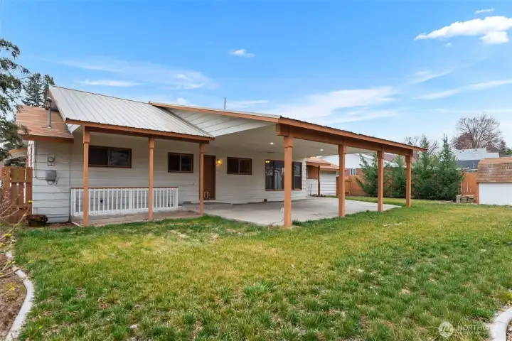 Back yard space and exterior entrance to basement on the left side of home.