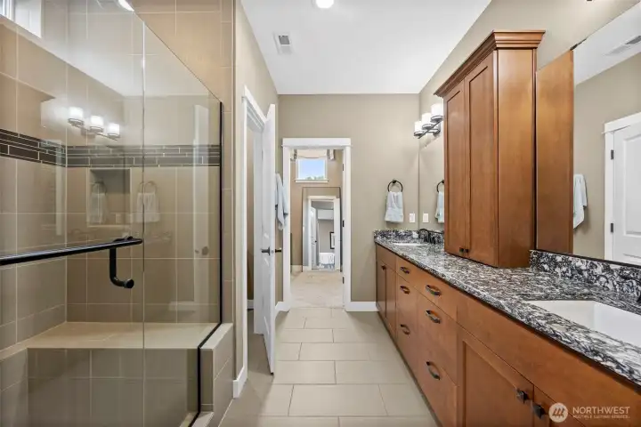 Yes! A gorgeous custom, tiled shower, and the amount of cabinetry in this spa-like bathroom is impressive!