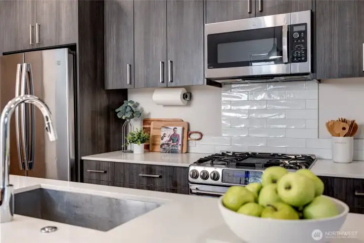 Designer Kitchen with Quartz Countertops and Stainless Steel Appliances Designer Kitchen with Quartz Countertops and Stainless Steel Appliances