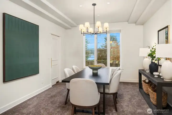 The sophisticated formal dining room features a statement chandelier, rich wainscoting, and a large window framing beautiful natural views, an elegant and intimate setting perfectly suited for hosting memorable dinners and special gatherings. The sophisticated formal dining room features a statement chandelier, rich wainscoting, and a large window framing beautiful natural views, an elegant and intimate setting perfectly suited for hosting memorable dinners and special gatherings.