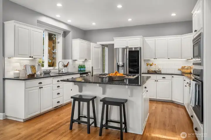 The expansive chef's kitchen impresses with crisp white cabinetry, a large center island with bar seating, premium stainless steel appliances, and abundant storage, beautifully designed for both everyday living and effortless entertaining with lake views just beyond. The expansive chef's kitchen impresses with crisp white cabinetry, a large center island with bar seating, premium stainless steel appliances, and abundant storage, beautifully designed for both everyday living and effortless entertaining with lake views just beyond.