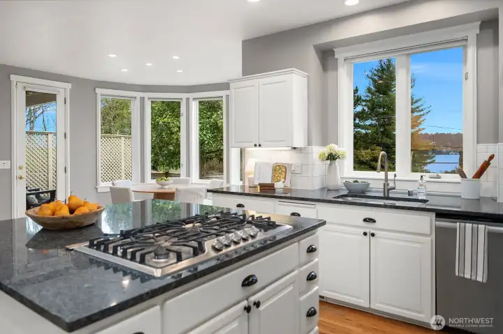 Cook with a view, this beautifully appointed kitchen features a premium gas range, dark granite countertops, and a large window perfectly framing the lush surroundings, making every moment in this kitchen a truly special experience. Cook with a view, this beautifully appointed kitchen features a premium gas range, dark granite countertops, and a large window perfectly framing the lush surroundings, making every moment in this kitchen a truly special experience.