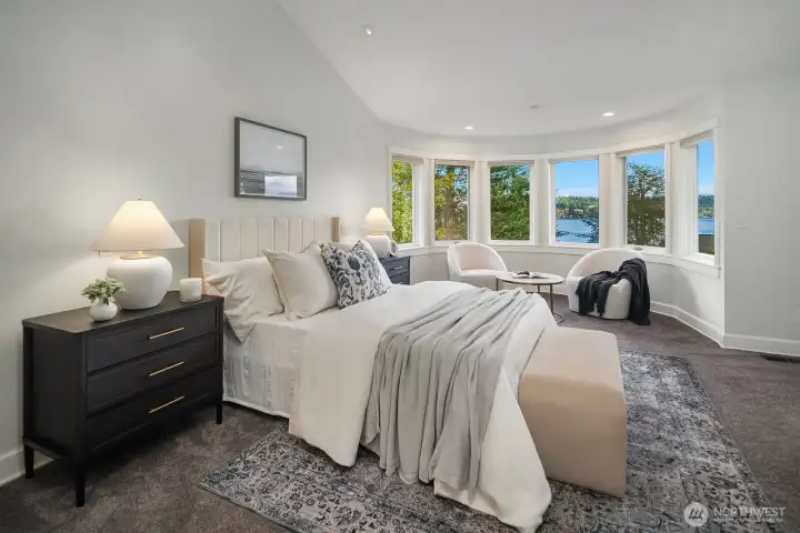 The serene upper-level primary suite offers a true retreat with vaulted ceilings, plush carpet, and beautiful lake views framed by large windows, a peaceful and private sanctuary designed for rest and relaxation. The serene upper-level primary suite offers a true retreat with vaulted ceilings, plush carpet, and beautiful lake views framed by large windows, a peaceful and private sanctuary designed for rest and relaxation.