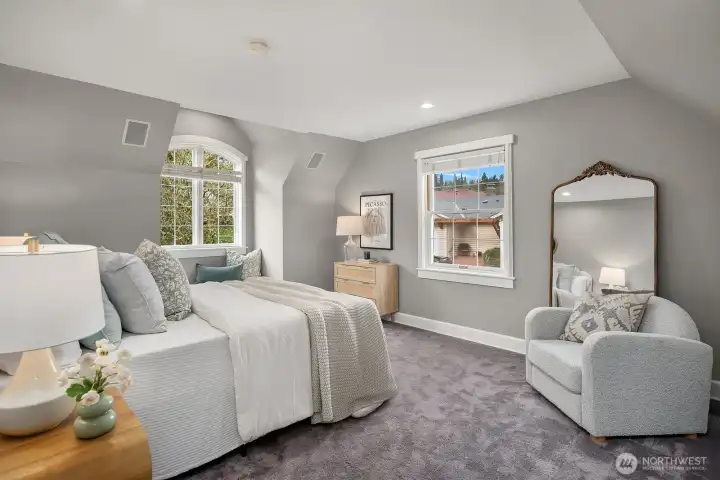 The expansive upper-level primary suite exudes elegance with plush carpeting, soft neutral tones, and beautiful lake views framed by large windows. A generous sitting area and refined finishes make this a true retreat at the end of the day. The expansive upper-level primary suite exudes elegance with plush carpeting, soft neutral tones, and beautiful lake views framed by large windows. A generous sitting area and refined finishes make this a true retreat at the end of the day.