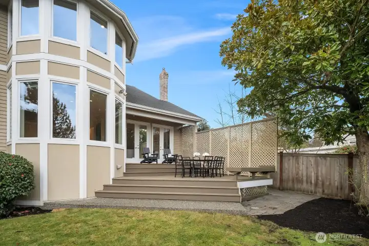 The fully fenced backyard offers a wonderful sense of privacy, featuring a expansive deck perfect for outdoor entertaining and a lush lawn bathed in natural light. Elegant architectural details on the home's exterior, including striking curved windows, add to the overall curb appeal and character of this custom residence. The fully fenced backyard offers a wonderful sense of privacy, featuring a expansive deck perfect for outdoor entertaining and a lush lawn bathed in natural light. Elegant architectural details on the home's exterior, including striking curved windows, add to the overall curb appeal and character of this custom residence.