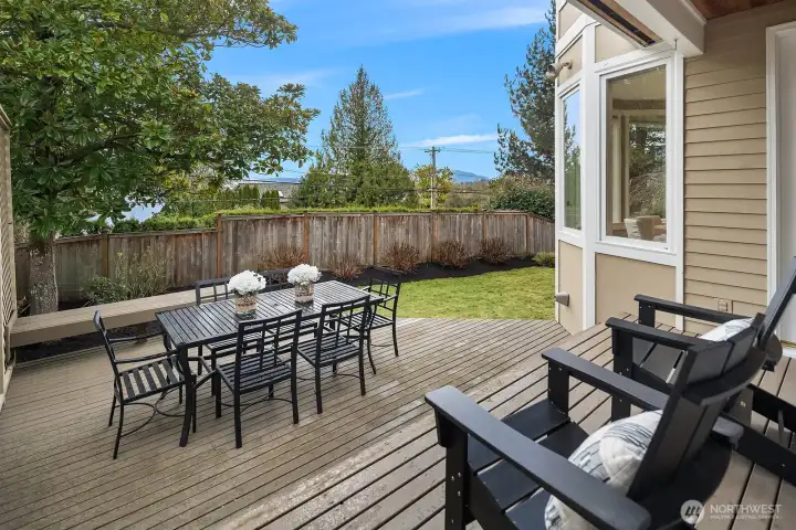 This generous deck is an entertainer's dream, offering ample space for al fresco dining with a large patio table set against a backdrop of lush greenery and peekaboo lake views. The seamless indoor-outdoor connection makes this the perfect spot to take in the natural surroundings during warm Pacific Northwest days. This generous deck is an entertainer's dream, offering ample space for al fresco dining with a large patio table set against a backdrop of lush greenery and peekaboo lake views. The seamless indoor-outdoor connection makes this the perfect spot to take in the natural surroundings during warm Pacific Northwest days.