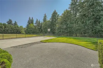 fenced portion of back yard with sports court