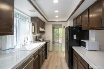Enjoy the kitchen’s oversized windows above the sink, perfectly framing the peaceful backyard view.