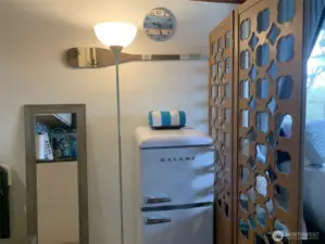 Just to the left of the bed.