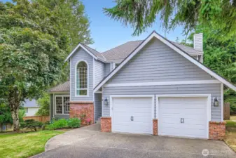 Inviting front elevation with clean lines, manicured lawn, and vibrant front door. Spacious driveway provides ample off-street parking.