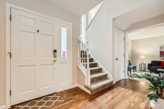 Bright entry with hardwood flooring, neutral tones, and stair access to the upper level. Adjacent to main living and formal spaces.
