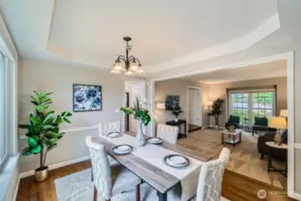 Open sight lines between dining and living areas. Elevated ceiling details and abundant natural light enhance the flow.