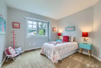 Bright and playful, this bedroom features calming wall colors, tree-top views, and a generous room size perfect for all ages.