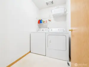 Spacious laundry room -- W&D stay! And note, there's room to add more shelving or cabinets.