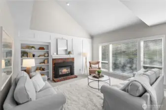 This great room off the kitchen is the best!  Oversized windows, gas fireplace, built in shelving, vaulted ceilings and more