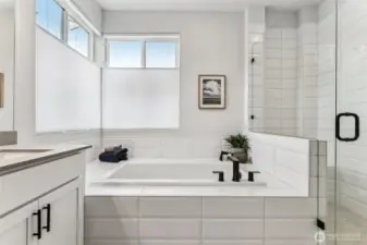 Pic is of model- Gorgeous primary bath, deep soaking tub w/gorgeous tile surround and 2 large operable windows.