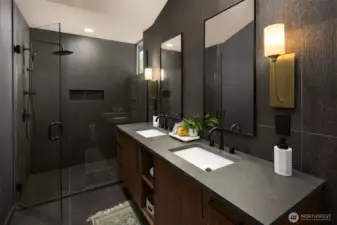 The primary bath is a bold selection of stone counters paired with black textured tile