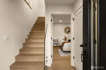 A bright and inviting foyer with soaring ceilings and designer lighting sets the tone for the rest of the residence, Features a bed and bath on the ground level, making for a perfect guest suite or office