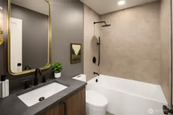 A full sized tub with a two showerhead arrangement- featuring a lighter finish