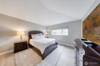 Spacious, contemporary primary bedroom with vaulted ceilings and abundant natural light (upstairs).