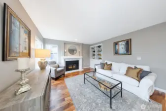 Warm and inviting main floor family room with gas fireplace, built-in shelving, and refined finishes throughout.