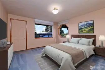 The Primary Bedroom with a cute octagonal window and a door leading out to the deck.