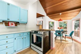 The cheerful kitchen has tall ceilings and is open to the dining room. The induction stove is a new Bespoke 6.3 cu. ft. Smart Rapid Heat Induction Range with Air Fryer + True Convection Oven, White Glass Finish (2023).