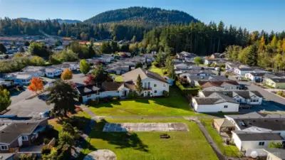 Among the amenities at Little Mountain Estates are shuffleboard and horse shoe pits.  The clubhouse is at center, and includes a heated, indoor pool, a library, a TV/gathering room, kitchen, and event space.  Little Mountain itself is at the back of this photo.