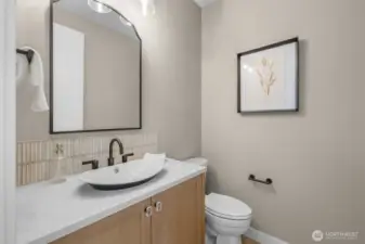 Stylish powder bath with designer tile accents, floating vanity, and contemporary finishes. A refined touch for guests and everyday living.