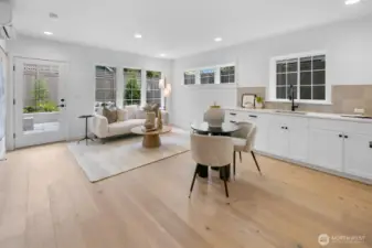 Light-filled lower-level living space with wide-plank hardwoods, kitchenette, and direct access to the private patio and backyard.