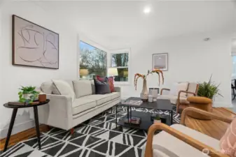 Sun-filled living room featuring original hardwoods and a classic picture window that fills the space with natural light.