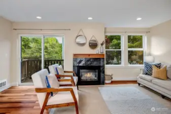 Spacious living room flanked by gas fireplace and balcony looking over the back yard
