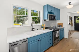 The second home's kitchen features quartz countertops, stylish tile back splash and new appliances.