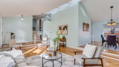 This view showcases the staircase leading to other areas of the home, along with a sightline of the dining room.