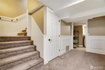 Welcome to the lower floor, where attention to detail is evident throughout. To the left you will find the mechanical room, a new heat pump with air conditioning installed 2024 and the water heater. Straight ahead is the laundry room, with additional storage. To the right is another closet, and the stairway leading to garage is also located in this hallway.