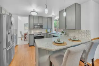 Updated kitchen on the main floor includes upgraded appliances, painted cabinets, and stone countertops.
