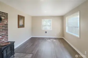 Light-filled living room with updated flooring creates a welcoming space to relax or gather.