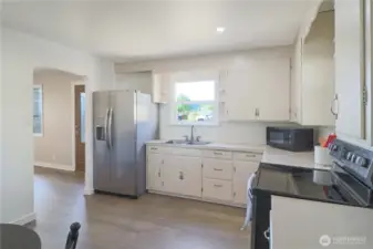 Second kitchen view showcases abundant cabinet space, stainless refrigerator and smooth top range - easy flow for daily living.