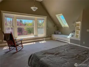 Palatial primary bedroom with bay window and extra sitting/sleeping area.
