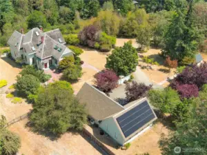 Solar panels installed on the roof of the shop/studio space. East side yard, including little cottage/play house.